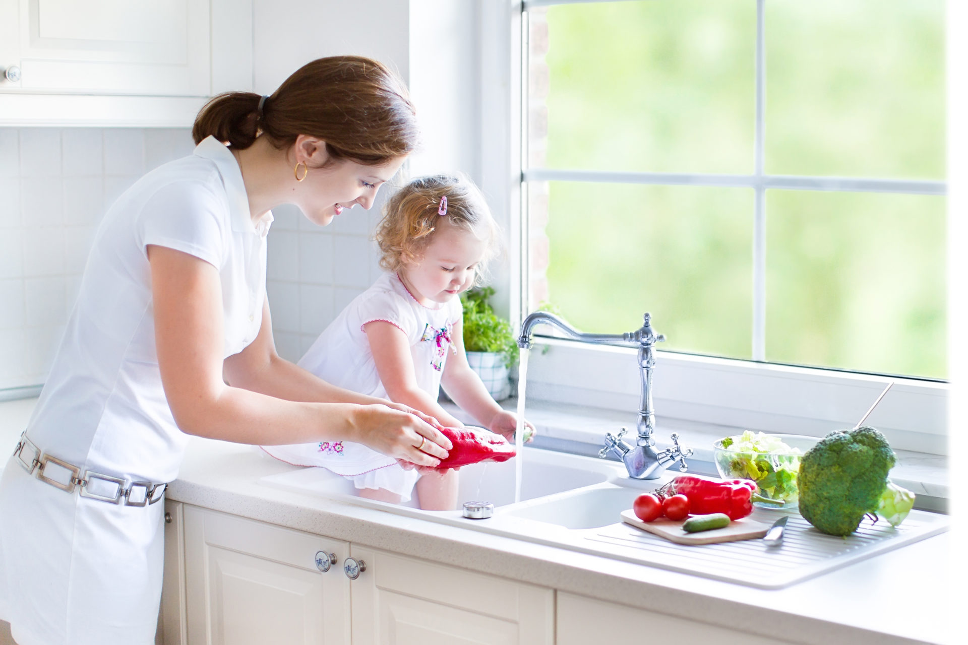 Woman and Child Washing Vegetables in Sink