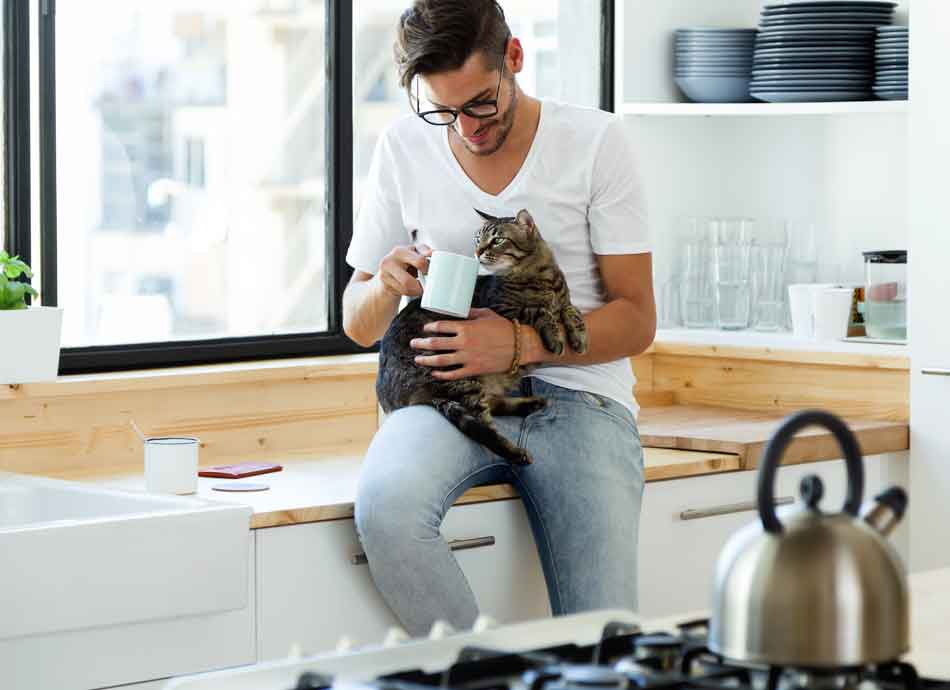 well_water_1 Young man sitting on counter with coffee cup and cat